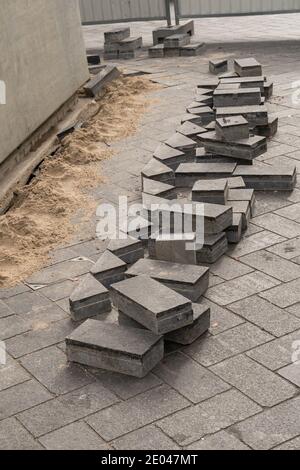 Preparation  for laying paving slabs on the gravel substrate. Sorted colored pavement tiles lined up in stacks Stock Photo