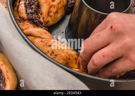 Young woman preparing the dough of chocolate cake in a round baking pan Stock Photo