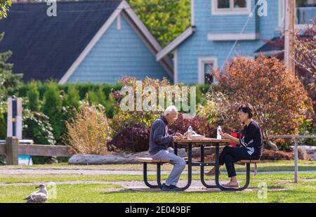 an elderly man with his adult daughter spending time together outdoor in the park. Stock Photo