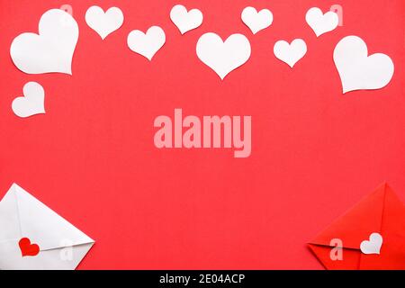 Background for Valentine's day. White and rat envelopes, white hearts on a red background. Stock Photo
