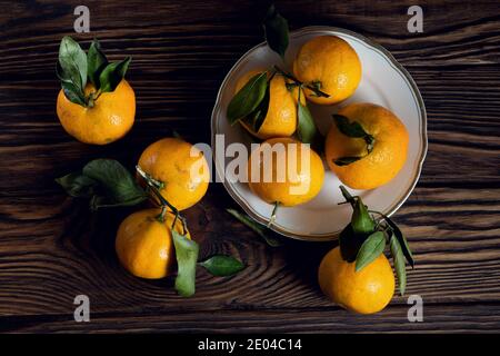 Orange mandarins on the dark brown textured boards Stock Photo