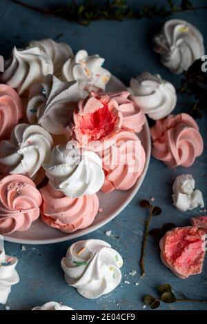 Pattern with delicate light white and pink meringue cookies on wooden background. Stock Photo