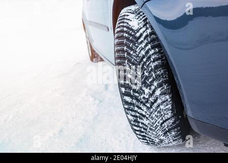 Car fitted with winter tyres on a snow covered mountain road. Copy Space.