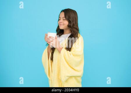 Relaxation before sleep. Drinking milk just before heading to bed. Bedtime Beverages. Evening routine. Health Benefits of Drinking Milk Before Bed. Little child hold mug. Girl in pajamas drinking tea. Stock Photo