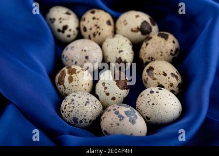 Fresh farm quail eggs on blue sateen cloth Stock Photo