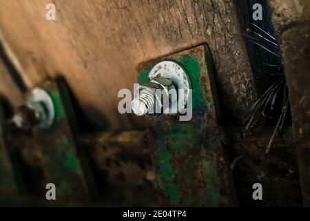 Nut with screw holds the old planks of a wooden bridge, detail. Stock Photo