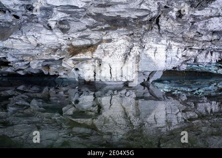 Underground Lake Inside the Ice Cave. Slope of the mountain with the reflection in the water inside a fantastic cave. Kungur In The Urals, Russia Stock Photo