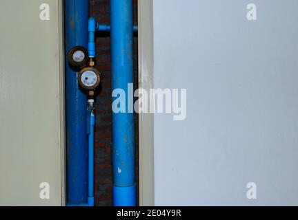 Selective focus of meter and water pipes in open shaft of residential building Stock Photo