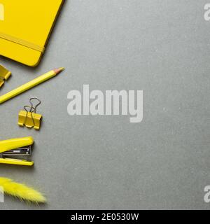 Yellow stationery office supplies. Notebook, clip, pencil, stapler on gray background. flat lay, top view, copy space Stock Photo