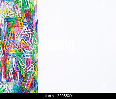 Colorful paper clips on white background top view with space for text or creativity on the right .Close up. Stock Photo