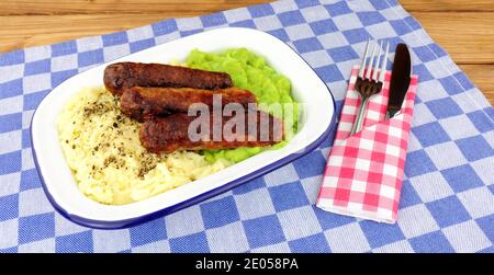 Sausage and mashed potato meal with mushy peas in a metal enamel dish Stock Photo