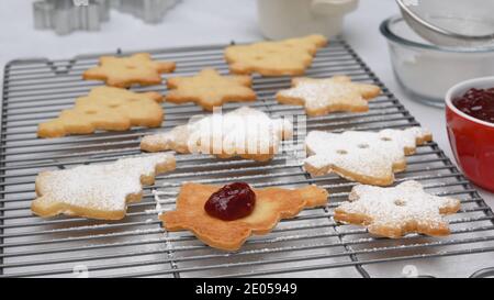 Christmas shortbread cookies with raspberry jam recipe, close up baking process. Baked cookies close up on cooling rack Stock Photo