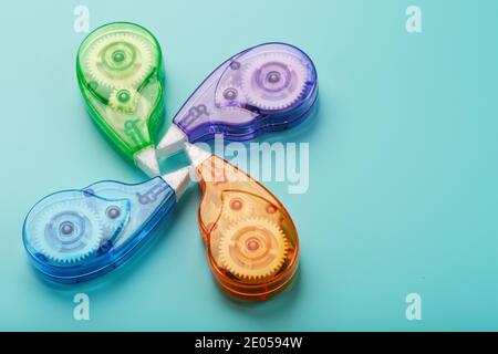 Stationery correction tapes are Multicolored on a blue background. Free space. The view from the top. Blue, green, yellow, lilac Stock Photo