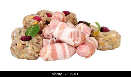 Group of raw pigs in blankets and pork stuffing balls with cranberries isolated on a white background Stock Photo