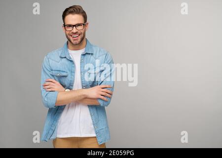Portrait of young handsome caucasian man in jeans shirt over light background Stock Photo