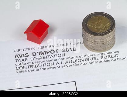 French housing tax, small houses and heap of euros coins. Public audiovisual contribution voted by the parliament written in french language. Stock Photo