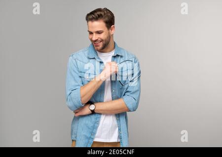 Portrait of young handsome caucasian man in jeans shirt over light background Stock Photo