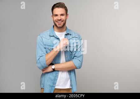 Portrait of young handsome caucasian man in jeans shirt over light background Stock Photo