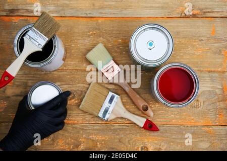 Paint cans and brushes on the old wooden background. Concept of house renovation Stock Photo