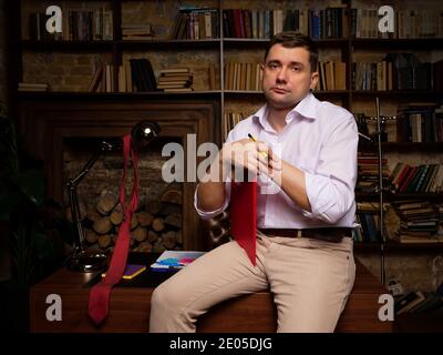 Portrait of a tired businessman in his office in the evening. Stock Photo