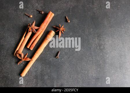 Spices on a dark background. Cinnamon sticks and anise stars. Stock Photo