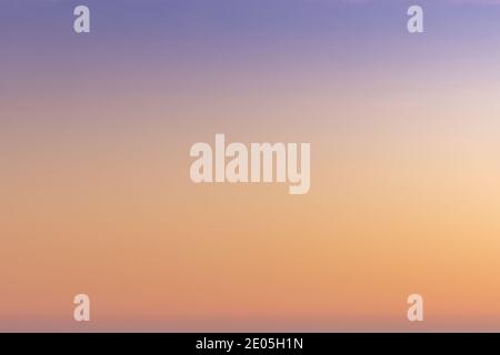 A gradient sunset sky background from orange and red to lilac and blue Stock Photo