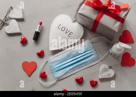 sad valentine's day during covid pandemic concept. black and white hearts with medical face mask and lipstick. celebrating love during a lock down and Stock Photo