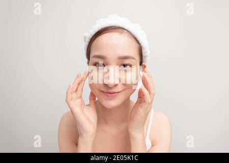 Indoor shot of calm relaxed woman has fresh healthy skin, wears collagen patches under eyes Stock Photo