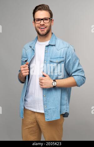 Portrait of young handsome caucasian man in jeans shirt over light background Stock Photo