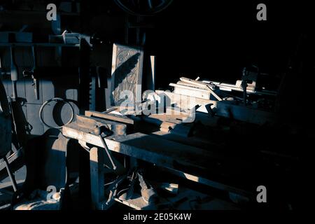 Old carpenters workshop with tools on wall and bench.  With colour toning Stock Photo
