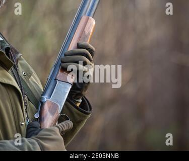 man  with shotgun close up wearing gloves Stock Photo