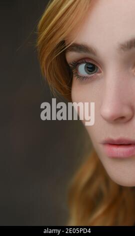 Close-up (half of face) of a naturally beautiful woman with good skin and strong features  (20) focused on eye with direct contact with copy space. Stock Photo