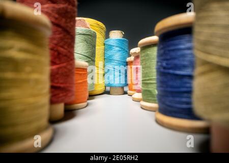 between colorful sewing thread spools. closeup Stock Photo