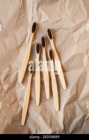 Many bamboo toothbrushes on beige paper background. Zero watse concept. Stock Photo