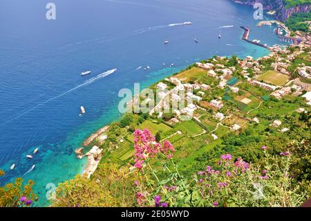 The shore of Capri island viewed from the coast, representing a part of green land and the blue sea, aerial view Stock Photo