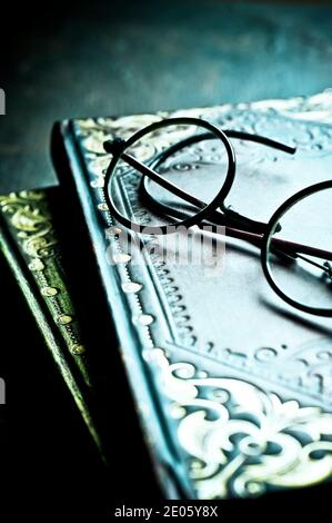 two old books stacked and reading glasses Stock Photo