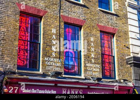 Neon signs in the windows of Hanks Acoustic Guitars shop on famous music shop street - Denmark Street, London, UK Stock Photo