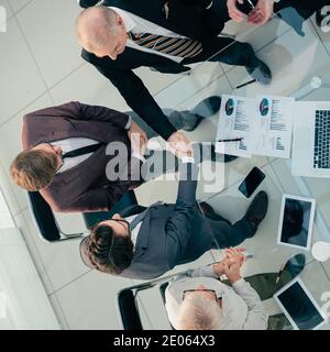top view. financial partners confirming the transaction with a handshake. Stock Photo