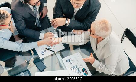 top view. senior businesswoman shaking hands with her young business partner . Stock Photo