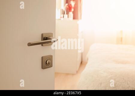 Opened door with metal knob close-up Stock Photo