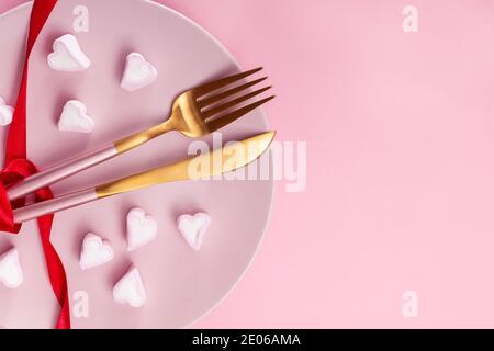 Fork and knife on the plate with hear shaped marshmallows Stock Photo