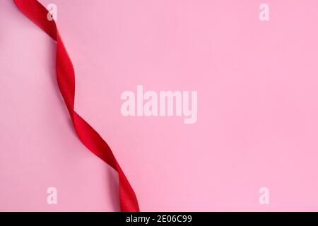 Red shiny ribbon on pink background Stock Photo
