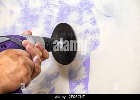Plasterer smoothing wall surface with wall machine sandpaper grinding machine. Copy space. Stock Photo