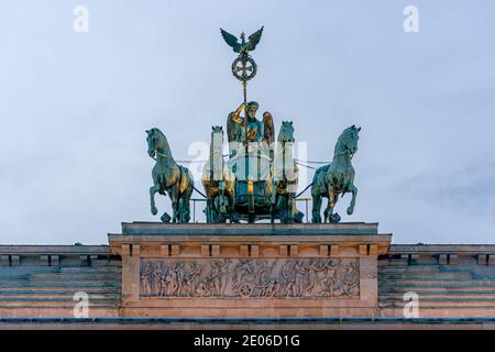 December 28, 2020, Berlin, Detail of the Brandenburg goal on a winter afternoon. The lighting of the Brandenburg goal shines on the quadriga and creates a special lighting atmosphere. The Quadriga by Johann Gottfried Schadow 1793, carried out by the coppersmith Emanuel Jury; Victoria, the goddess of victory, brings peace to the city on a team of four. Below is the sandstone attic relief, designed in 1791 by Bernhard Rode and made by the sculptors Conrad Nicolaus Boy and Christian Unger. | usage worldwide Stock Photo