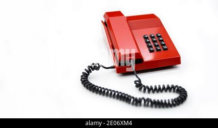 Desktop telephone from the 80's and red color isolated on a white background. Space for text. Communication concept. Stock Photo