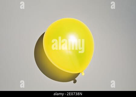 Yellow balloon on gray background. Photo in colors of the year 2021 Stock Photo