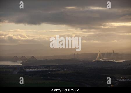 The three bridges over the Firth of Forth, Rail Bridge, Road Bridge and Queensferry Crossing seen from the Hill of Beath at sunset. Stock Photo