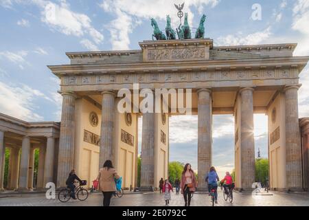 Berlin, Germany - April 26 2015: Tourists and locals enjoy early evening sun at the iconic Brandenburg Gate in Berlin, Germany Stock Photo