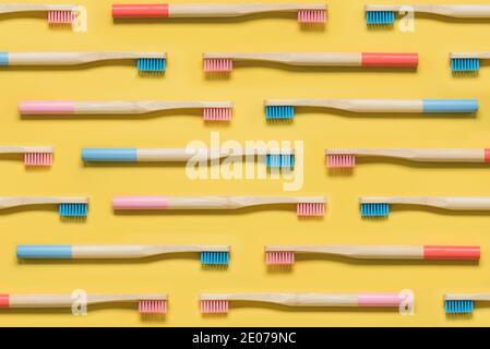 interlocking Colorful bamboo toothbrushes on yellow background Stock Photo