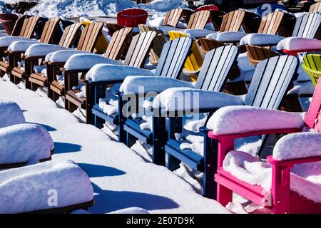 Colorful Adirondack style chairs in fresh snow; retail store; Poncha Springs; Colorado; USA Stock Photo